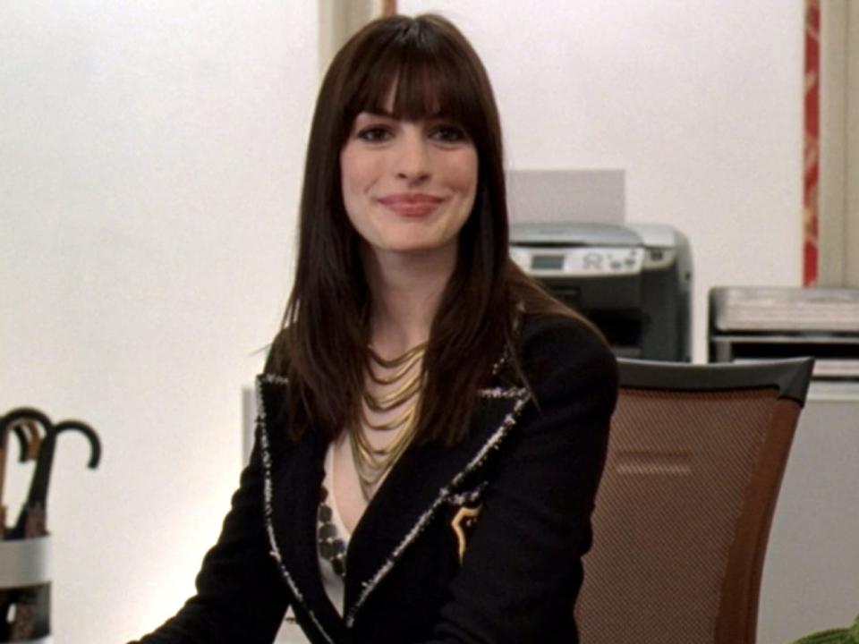 Anne Hathaway typing at a desk in "The Devil Wears Prada."