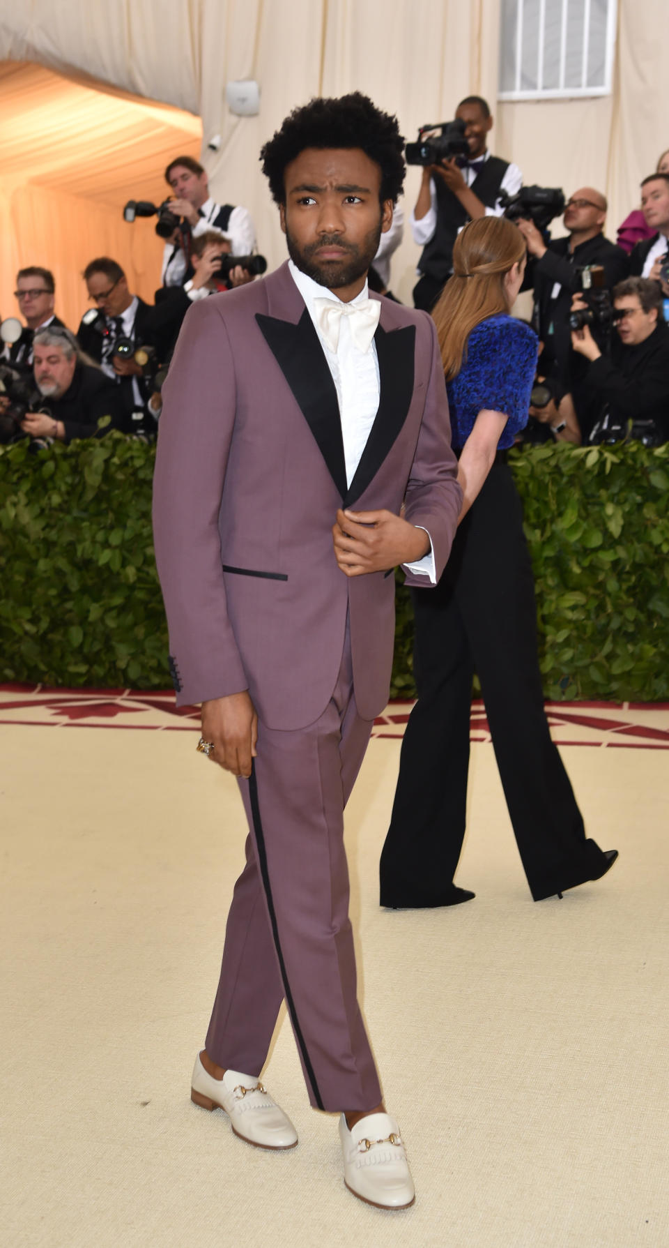 <p>In keeping with the theme, Donald Glover donned a Gucci tux with a seriously embellished symbol on the reverse. Dubbed the ‘Eye of Providence’, the pyramid symbolises the all-seeing eye of God.<br>Found on the back of a dollar note, the image could also hint at the Vatican’s accumulation of wealth over the centuries. Having just dropped his new album, ‘This Is America’, he is certainly not afraid to make a statement. He finished the look with a pair of white Gucci loafers, of course. <em>[Photo: Getty]</em> </p>