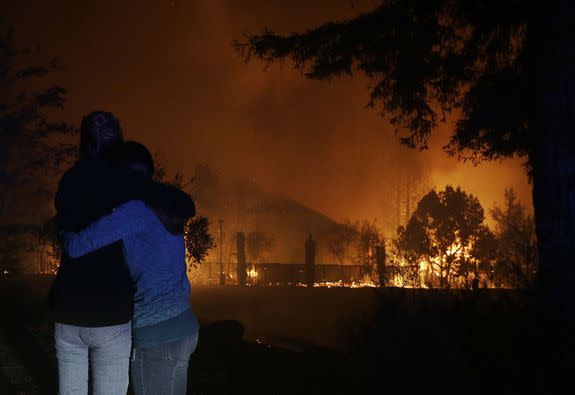 Two women hug as they watch houses burn in Santa Rosa, California on October 9, 2017