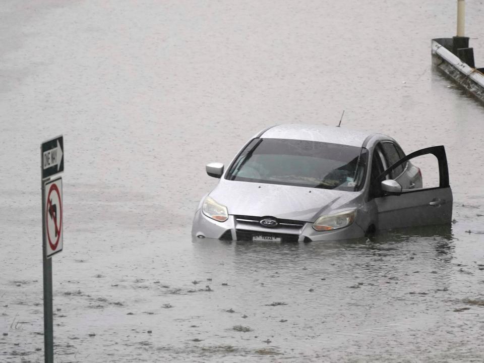 A car sits in flood waters covering a closed highway in Dallas, Monday, Aug. 22, 2022.
