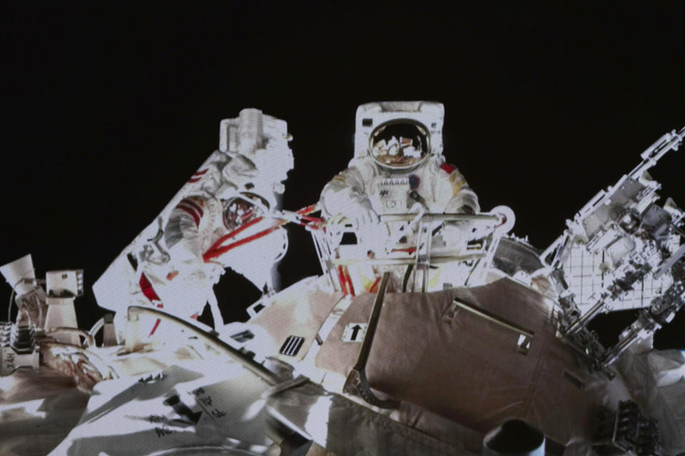 In this image released by the Xinhua News Agency, a photo taken on a screen shows Chinese astronaut Wang Yaping steps out from the space station's Tianhe core module, at Beijing Aerospace Control Center on Sunday, Nov. 7, 2021. Wang Yaping has become the first Chinese woman to conduct a spacewalk as part of a six-month mission to the country's space station. Wang and fellow astronaut Zhai Zhigang left the station's Tianhe core module on Sunday evening Beijing time, spending more than six hours installing equipment and carrying out tests alongside the station's robotic service arm. (Guo Zhongzheng/Xinhua via AP)