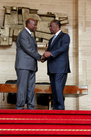 Ivory Coast President Alassane Ouattara (R) and Prime Minister Daniel Kablan Duncan pose for pictures as Duncan presents the resignation of his government in the Presidential Palace in Abidjan, Ivory Coast January 9, 2017. REUTERS/Thierry Gouegnon