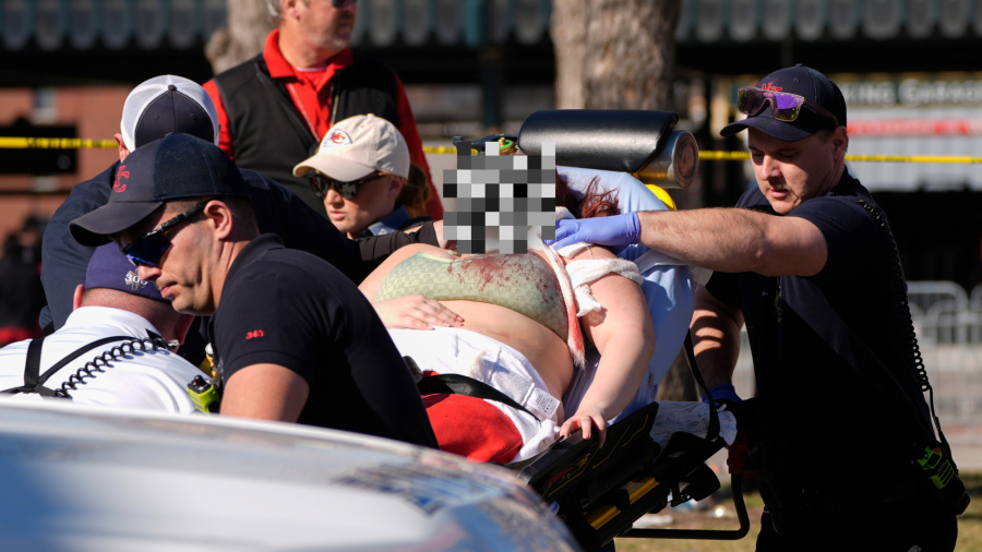 A person is taken to an ambulance following a shooting at the Kansas City Chiefs NFL football Super Bowl celebration in Kansas City, Mo., Wednesday, Feb. 14, 2024. Multiple people were injured, a fire official said. (AP Photo/Charlie Riedel)