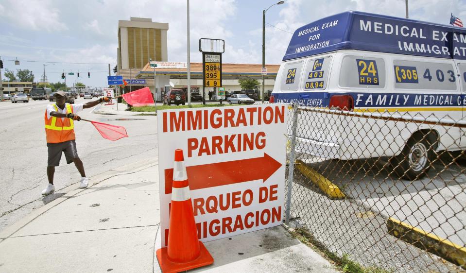 FILE - A parking lot attendant signals for people going to the Immigration Center in Miaimi to park Friday June 13, 2008. By the end of the century, the U.S. population will be declining without substantial immigration, senior citizens will outnumber children and the share of white residents who aren't Hispanic will be less than half of the population, according to population projections released Thursday, Nov. 9, 2023 by the U.S. Census Bureau. (AP Photo/J. Pat Carter, File)