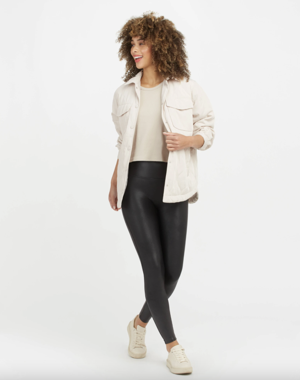 black model with curly hair wearing white shirt and black Faux Leather Leggings  Spanx