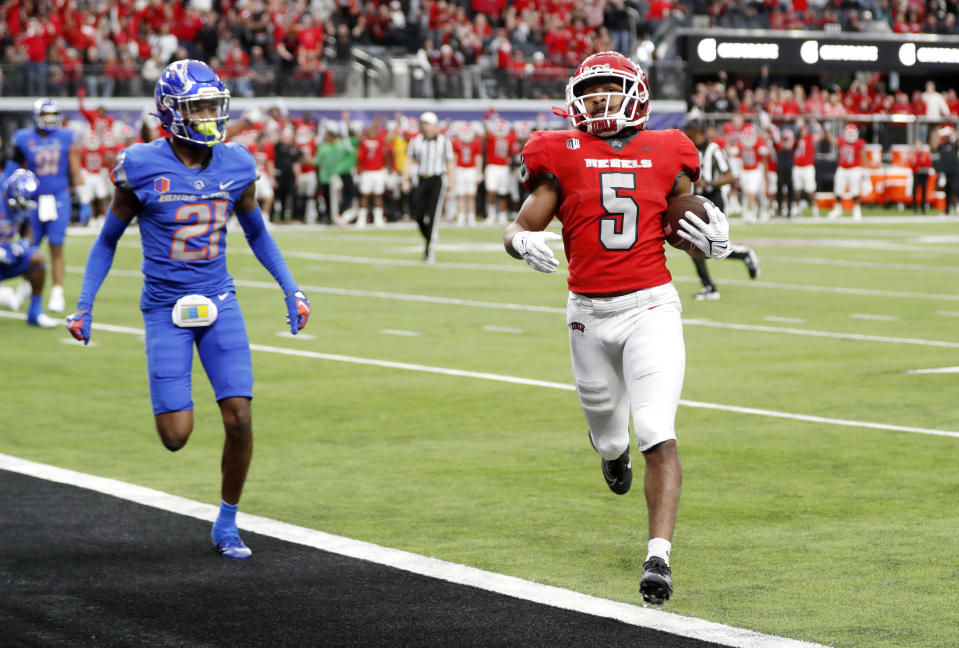 UNLV running back Vincent Davis Jr. (5) runs for a touchdown ahead of Boise State cornerback A'Marion McCoy (21) during the first half of the Mountain West championship NCAA college football game Saturday, Dec. 2, 2023, in Las Vegas. (Steve Marcus/Las Vegas Sun via AP)