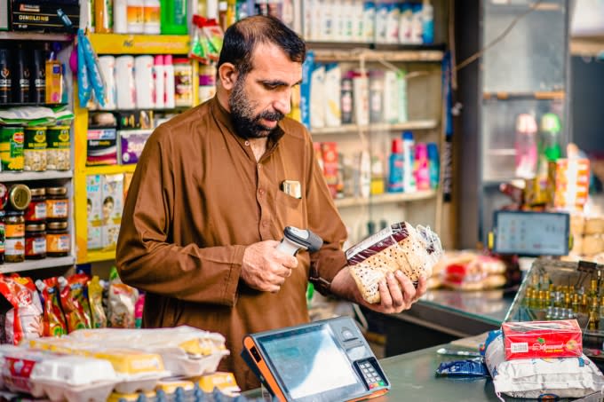 A kiryana owner with one of SnappRetail's point-of-sale devices