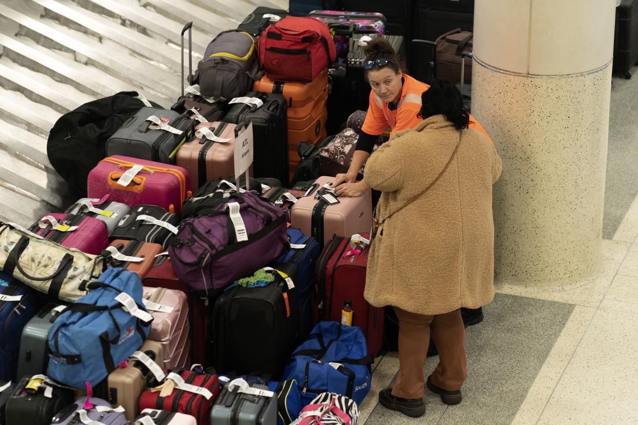 A Southwest Airlines employee helps a traveler search for bags amongst hundreds of other checked bags at baggage claim at Midway International Airport as Southwest continues to cancel thousands of flights across the country Wednesday, Dec. 28, 2022, in Chicago. (AP Photo/Erin Hooley)