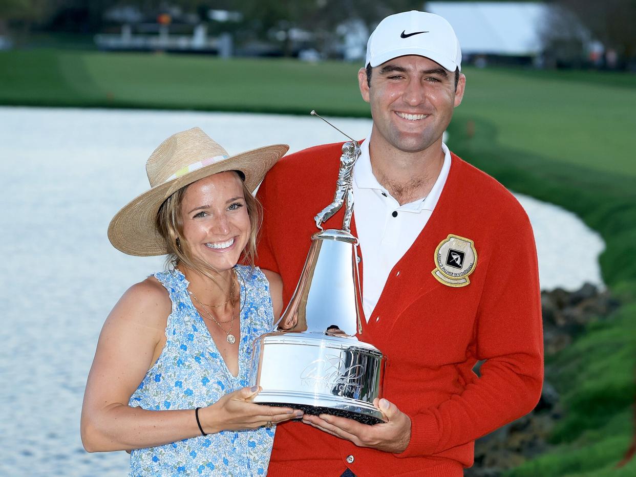 Scottie Scheffler of The United States holds the trophy with his wife Meredith Scheffler after his one stroke win in the final round of the Arnold Palmer Invitational presented by Mastercard at Arnold Palmer Bay Hill Golf Course on March 06, 2022 in Orlando, Florida