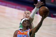 Oklahoma City Thunder guard Shai Gilgeous-Alexander, front, gets past Dallas Mavericks center Kristaps Porzingis for a shot during the second half of an NBA basketball game in Dallas, Wednesday, March 3, 2021. (AP Photo/Tony Gutierrez)