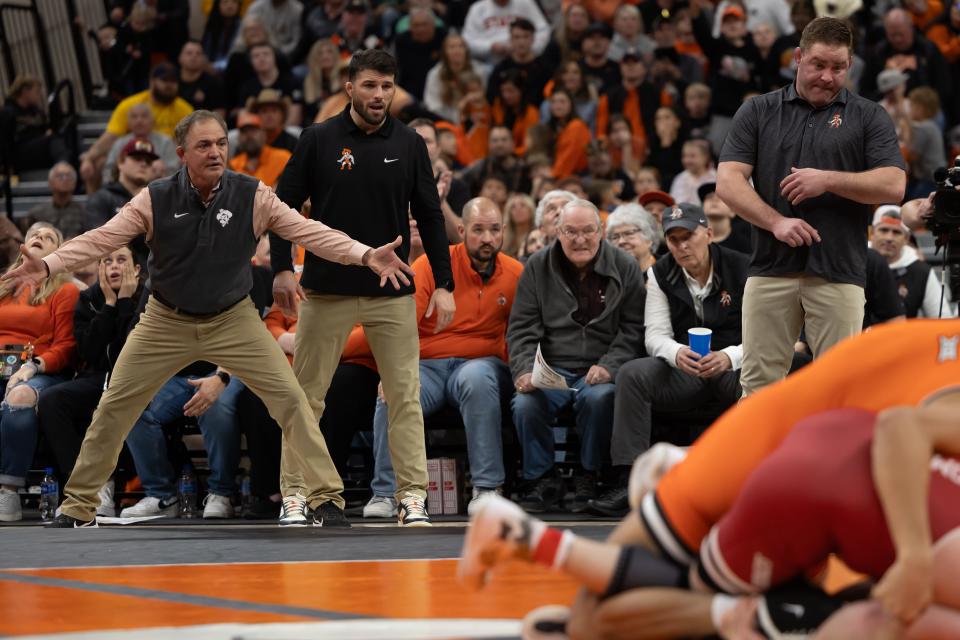 Feb 18, 2024; Stillwater, Okla, USA; Oklahoma StateÕs head coach John Smith (left), assistant coach Tyler Caldwell (center) and assistant coach Chris Perry react on the side of the mat during a wrestling dual versus Oklahoma at Gallagher-Iba Arena in Stillwater, Okla. Mandatory Credit: Mitch Alcala-The Oklahoman