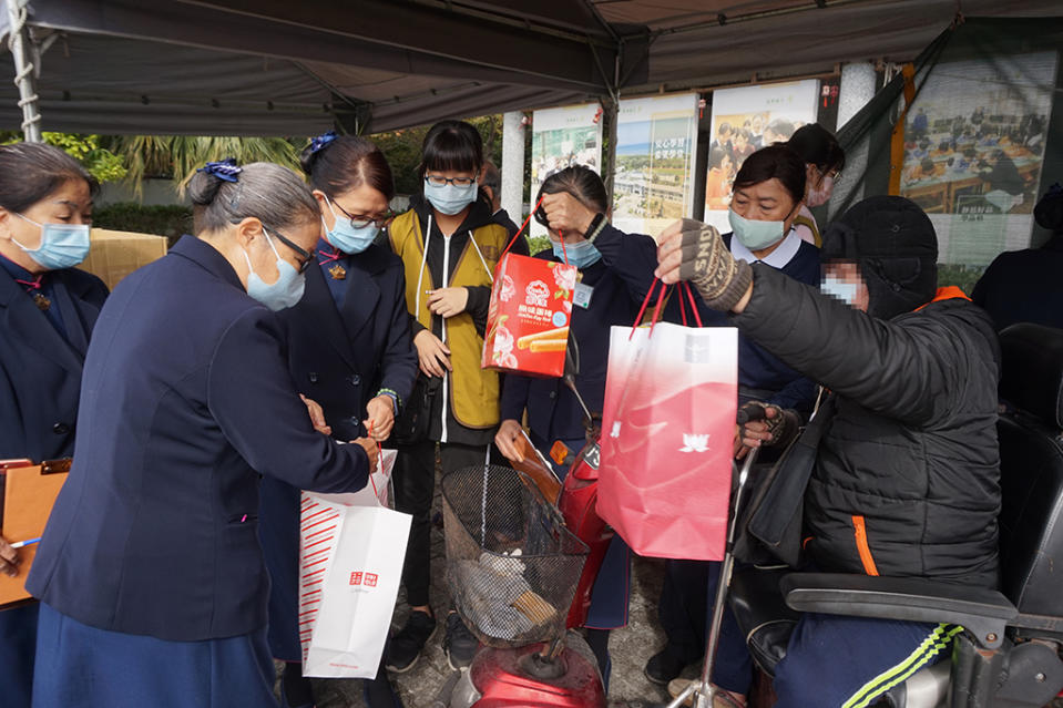 慈濟志工合心協助將歲末物資品整理，讓照顧戶安全載運車上。