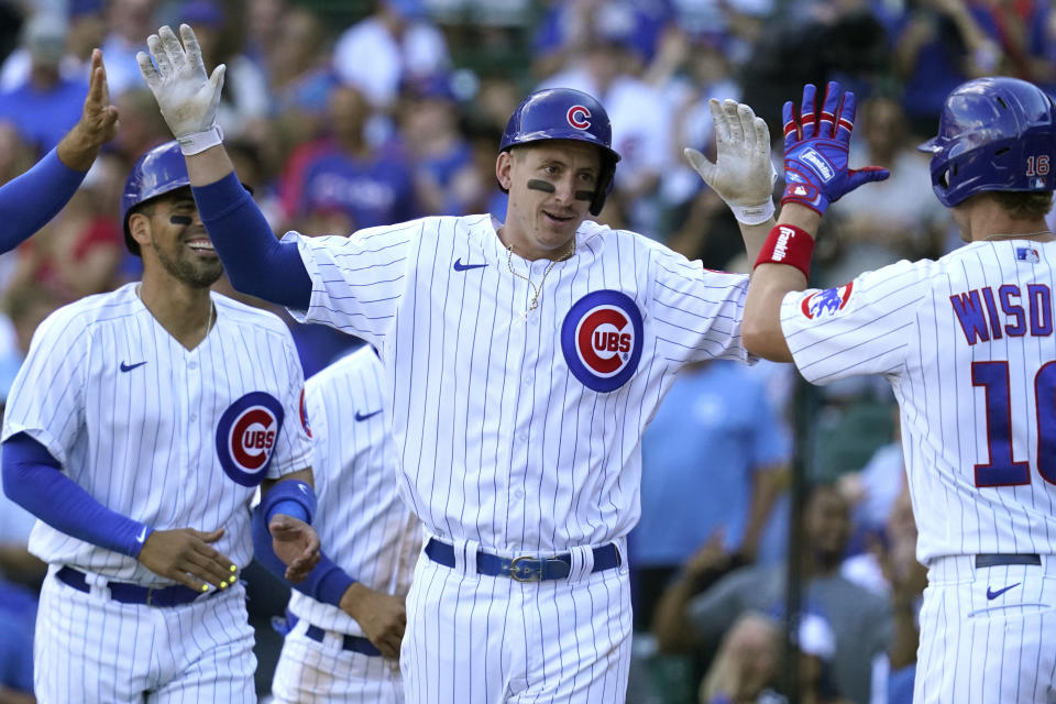 Chicago Cubs' Frank Schwindel, center, celebrates with Patrick Wisdom, right, after hitting a grand slam during the seventh inning of a baseball game against the Pittsburgh Pirates in Chicago, Sunday, Sept. 5, 2021. (AP Photo/Nam Y. Huh)