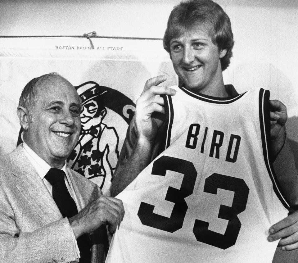 Former Indiana State basketball star Larry Bird displays his new Celtics uniform bearing the number 33, assisted by Celtics President Red Auerbach, left, at a news conference in Boston on Friday, June 8, 1979. The 6-foot-9 Bird became the richest rookie in sports history when he signed a Celtics contact calling for $3.25 million over five years.