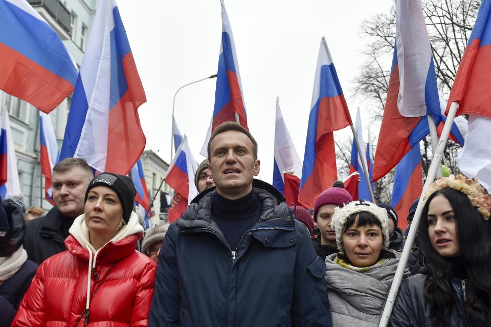 Russian opposition activist Alexei Navalny, center, and his wife Yulia, left, take part in a march in memory of opposition leader Boris Nemtsov in Moscow, Russia, Sunday, Feb. 24, 2019. Thousands of Russians took to the streets of downtown Moscow to mark four years since Nemtsov was gunned down outside the Kremlin. (AP Photo/Dmitry Serebryakov)