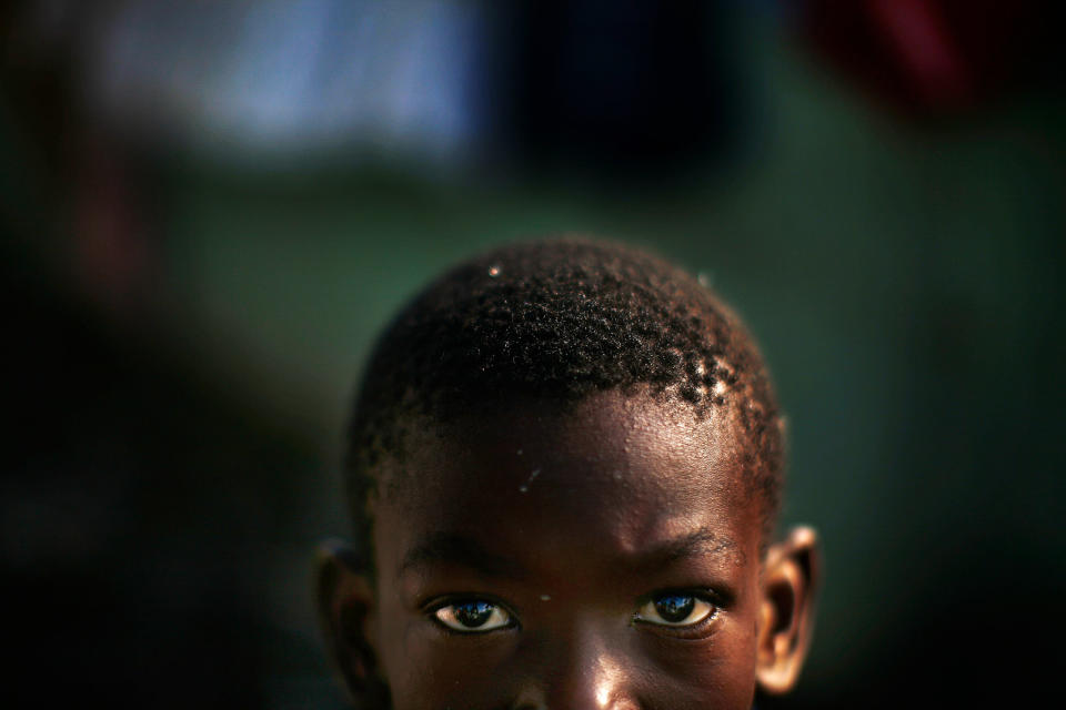 Alex Mertulus, 10, the son of Magarette Brutus, stands in the mud in the Mais Gate Camp after heavy rains flooded the area in the middle of the night in Port-au-Prince. Quake survivors were trying to stay dry and dig out of the mud in the tent camps of the Haitian capital, a warning of fresh misery for the 1 million homeless living on the streets and in IDP camps one month after the devastating earthquake.