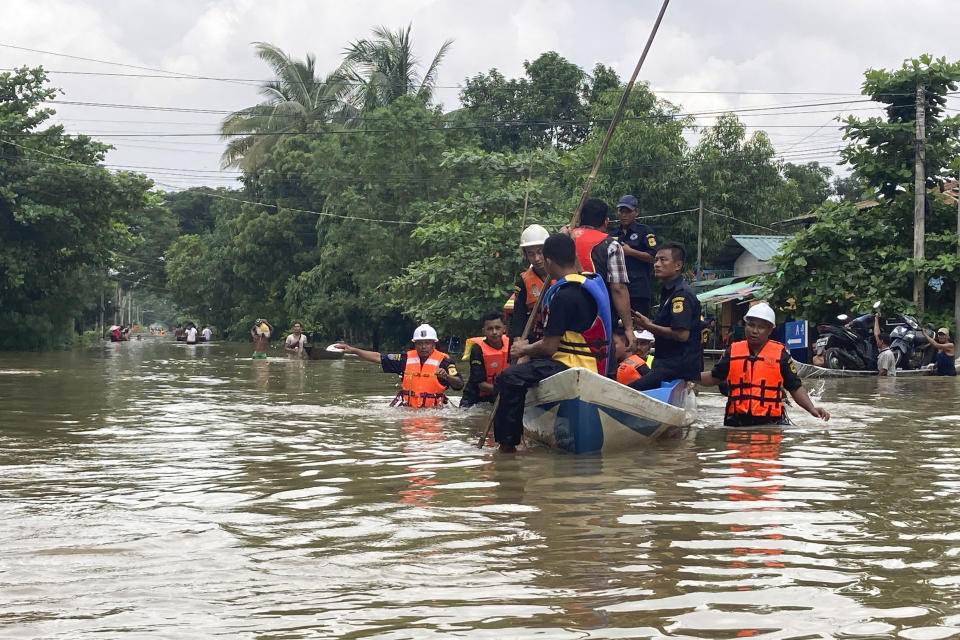 Members of a rescue team carry residents in a boat along a flooded road in Bago, Maynmar, about 80 kilometers (50 miles) northeast of Yangon, Friday, Aug. 11, 2023. (AP Photo)