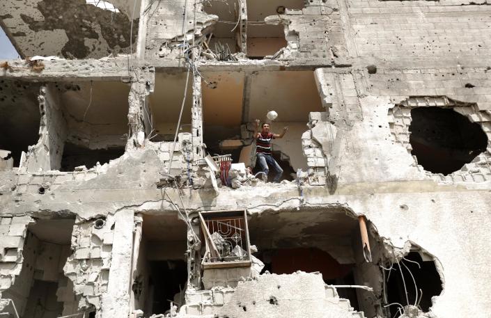 A Palestinian man throws an item from a destroyed house in the Al-Shejaea neighbourhood of Gaza City on August 5, 2014 (AFP Photo/Mohammed Abed)