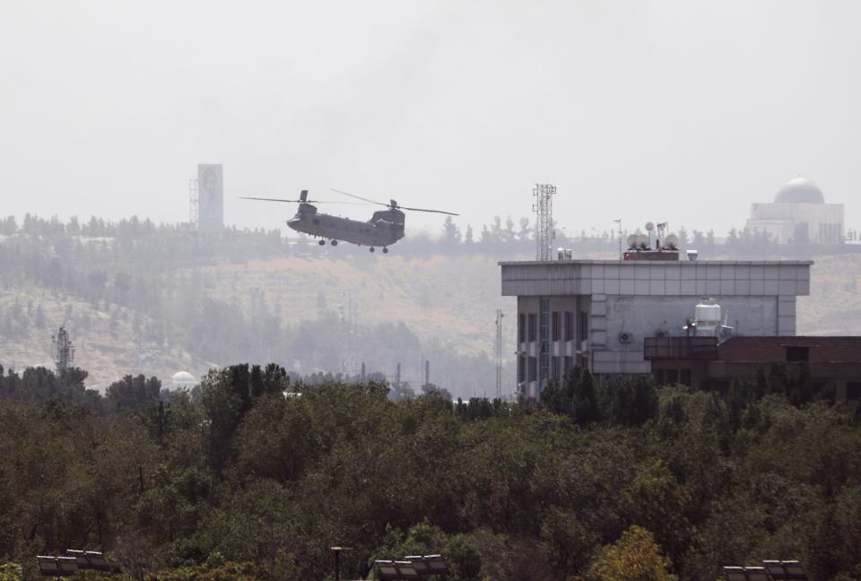 A U.S. Chinook helicopter flies near the U.S. Embassy in Kabul, Afghanistan, Sunday, Aug. 15, 2021. Helicopters are landing at the U.S. Embassy in Kabul as diplomatic vehicles leave the compound amid the Taliban advanced on the Afghan capital.