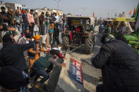 Protesting farmers remove police barricades as they march to the capital during India's Republic Day celebrations in New Delhi, India, Tuesday, Jan.26, 2021. Tens of thousands of farmers drove a convoy of tractors into the Indian capital as the nation celebrated Republic Day on Tuesday in the backdrop of agricultural protests that have grown into a rebellion and rattled the government. (AP Photo/Altaf Qadri)