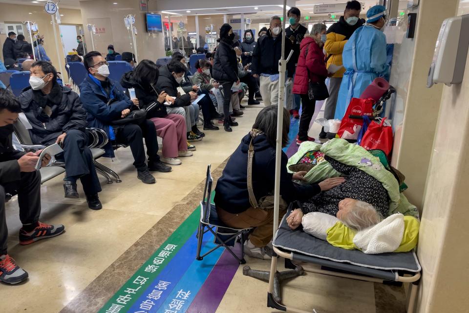 A woman looks after her elderly relative lying on a stretcher as patients receive intravenous drips in the emergency ward of a hospital in Beijing, Thursday, Jan. 5, 2023. Patients, most of them elderly, are lying on stretchers in hallways and taking oxygen while sitting in wheelchairs as COVID-19 surges in China's capital Beijing.