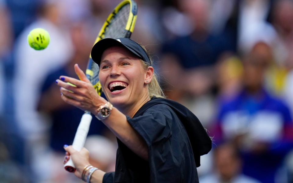 Caroline Wozniacki, of Denmark, hits balls to fans after defeating Jennifer Brady, of the United States, during the third round of the U.S. Open tennis championships