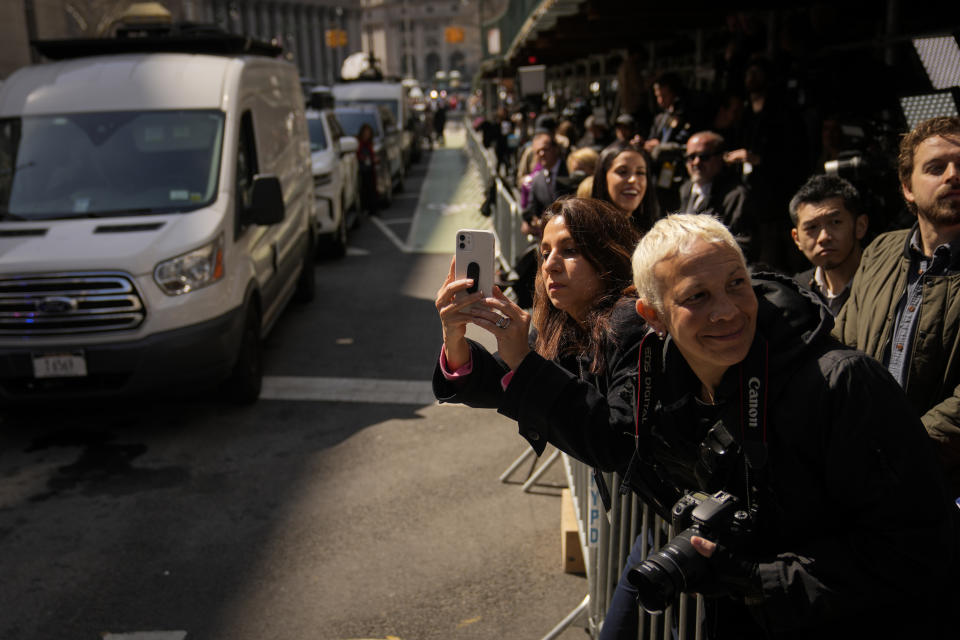 Curiosos y miembros de los medios de comunicación se reúnen frente al Tribunal Penal de Manhattan el martes 4 de abril de 2023, en Nueva York. El expresidente Donald Trump, que enfrenta múltiples investigaciones relacionadas con las elecciones, fue procesado en la corte el martes por cargos penales derivados de pagos de dinero a cambio de silencio en 2016. (AP Foto/John Minchillo)