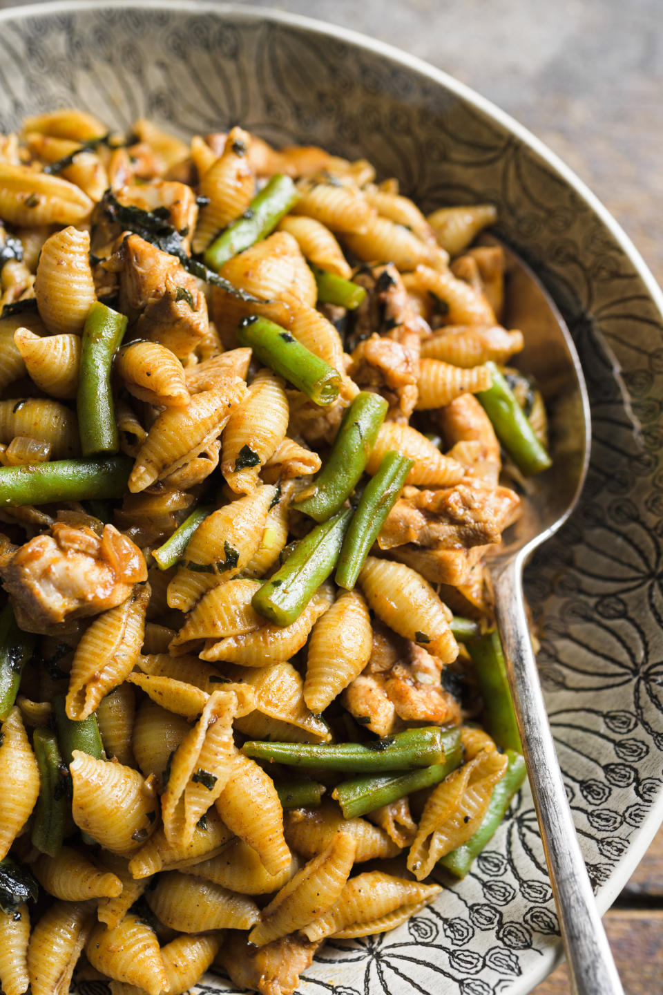 This image released by Milk Street shows a recipe for harissa-spiced pasta with chicken and green beans. (Milk Street via AP)