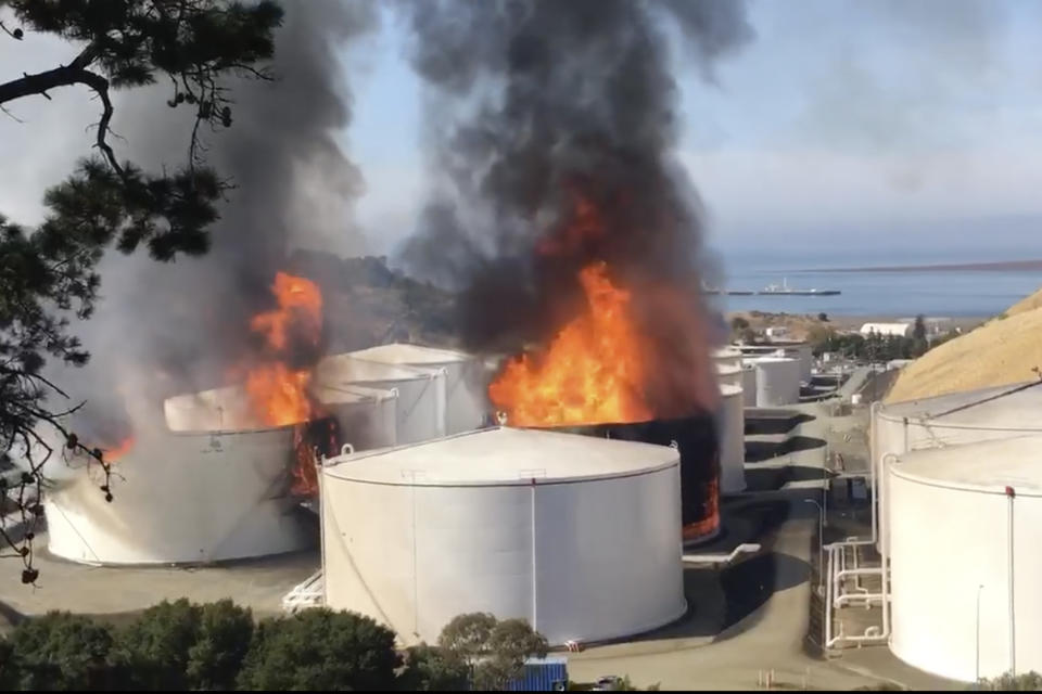 ADDS NAME AND LOCATION OF OIL STORAGE FACILITY In this image from video provided by the Napa County Sheriff's Office, tanks are on fire at an oil storage facility Tuesday, Oct. 15, 2019, viewed from Rodeo, Calif. A fire burning at NuStar Energy LP facility in Crockett, Calif, in the San Francisco Bay Area prompted a hazardous materials emergency that led authorities to order the residents of two communities, Crockett and Rodeo, Calif., to shelter in place and stay inside with all windows and doors closed. Contra Costa Fire Department spokesman Steve Hill said that an hour into battling the blaze, firefighters seemed to be making progress and were continuing to keep adjacent tanks cooled with water. (Henry Wofford/Napa County Sheriff's Office via AP)
