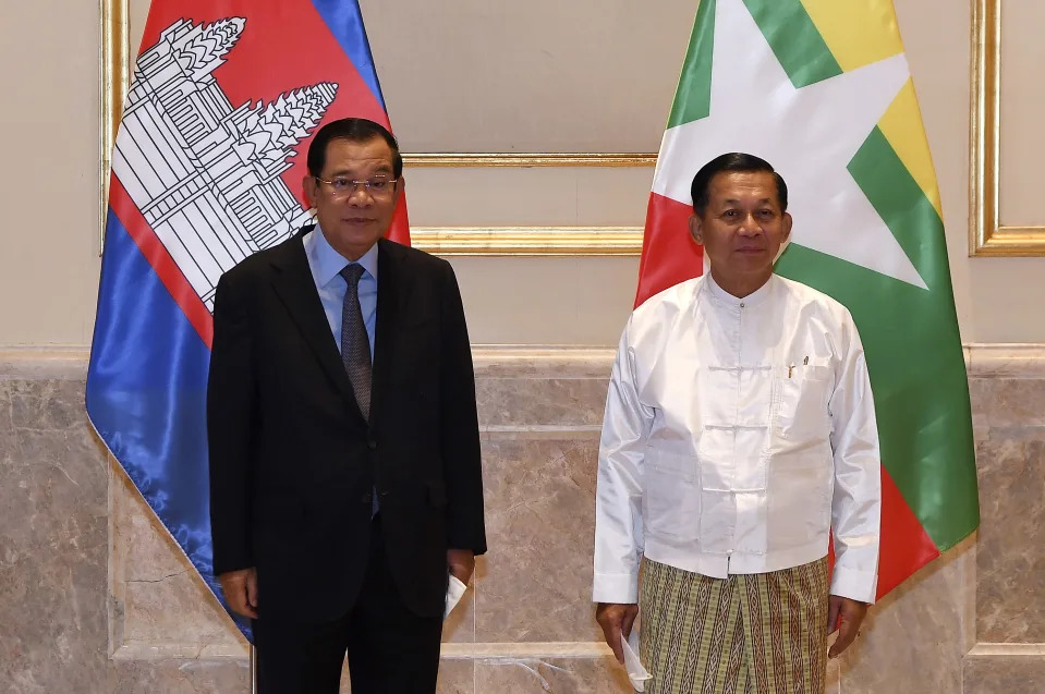 In this photo provided by An Khoun Sam Aun/National Television of Cambodia, Cambodian Prime Minister Hun Sen, left, poses for photographs together with Myanmar State Administration Council Chairman, Senior General Min Aung Hlaing, right, before holding a meeting in Naypyitaw, Myanmar, Friday Jan. 7, 2022. Cambodian Prime Minister Hun Sen's visit to Myanmar seeking to revive peace efforts after last year's military takeover has provoked an angry backlash among critics, who say he is legitimizing the army's seizure of power. (An Khoun SamAun/National Television of Cambodia via AP)