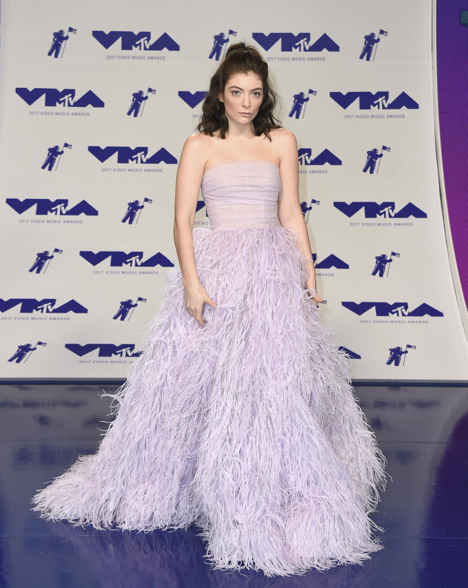 <p>Lorde had a total princess moment in a lilac gown with a strapless bodice and feather skirt. With the fancy dress, she kept her hair casual with a half-up, half-down topknot. (Photo: AP) </p>