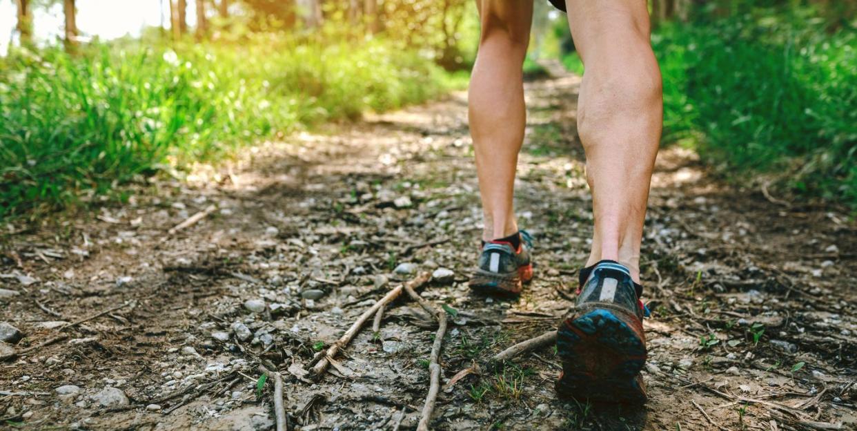 detail of feet of young man participating in a trail race through the forest