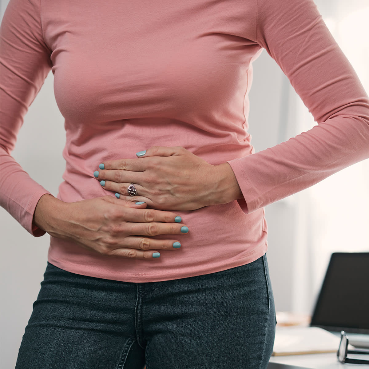 woman holding stomach in pain