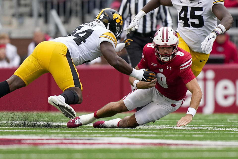 Wisconsin quarterback Tanner Mordecai (8) scrambles against Iowa linebacker Jay Higgins (34) during the first half of an NCAA college football game Saturday, Oct. 14, 2023, in Madison, Wis. (AP Photo/Andy Manis)