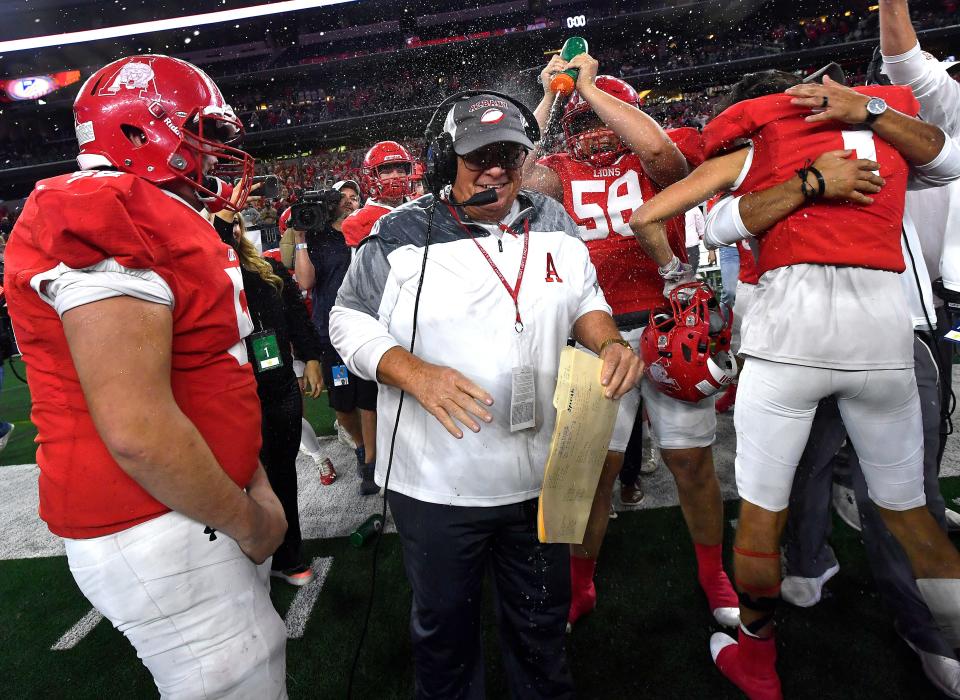 Albany linebacker Parker Shelton squirts Coach Denney Faith with a water bottle as the Lions celebrate their UIL Class 2A Div. 2 state football championship win over Mart at AT&T Stadium in Arlington Wednesday Dec. 14, 2022. Final score was 41-21, Albany.