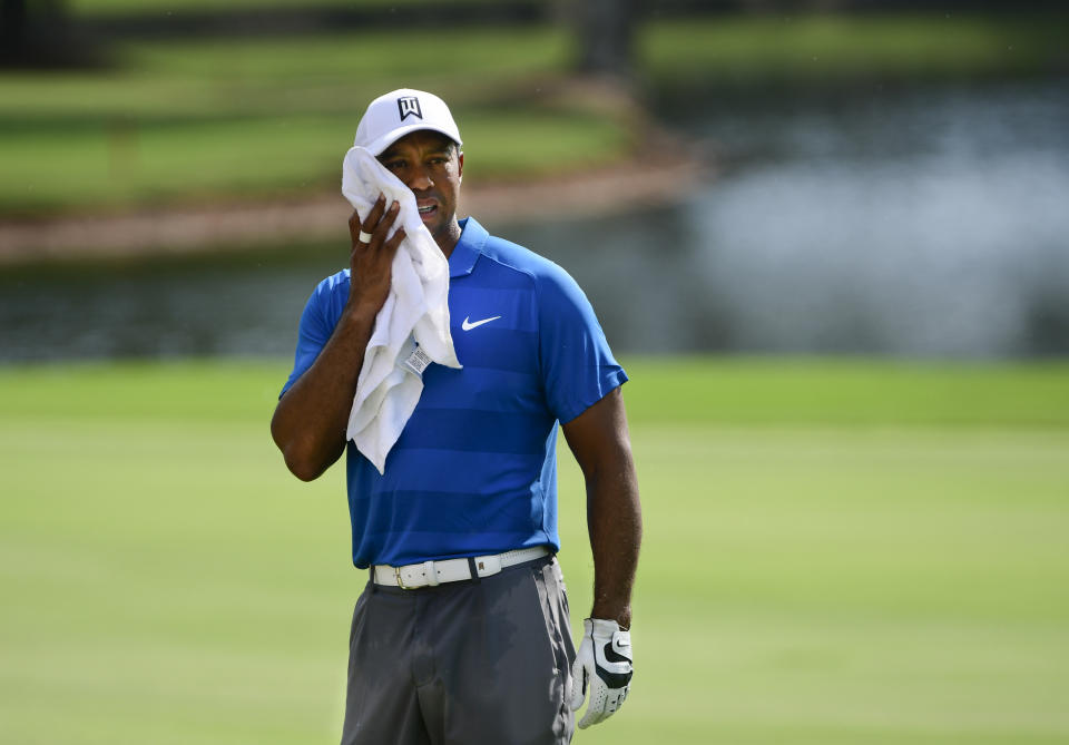 Tiger Woods wipes his face while sizing up his shot from the seventh fairway during the third round of the Tour Championship golf tournament Saturday, Sept. 22, 2018, in Atlanta. (AP Photo/John Amis)