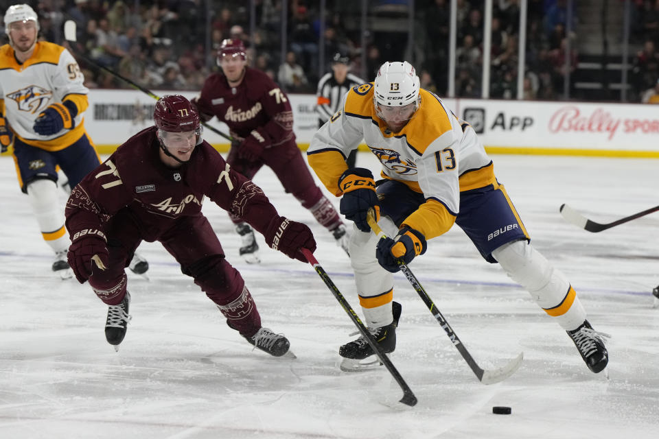 Nashville Predators center Yakov Trenin (13) drives against Arizona Coyotes defenseman Victor Soderstrom (77) in the second period during an NHL hockey game, Sunday, Feb. 26, 2023, in Tempe, Ariz. (AP Photo/Rick Scuteri)