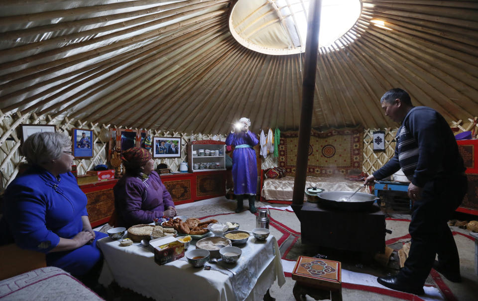 <p>Tanzurun Darisyu, second from left, head of a Tuvan private farm in the Kara-Charyaa area, has a meal with her neighbours and relatives inside a yurt south of Kyzyl town, the administrative center of the Republic of Tuva (Tyva region) in southern Siberia, Russia, on Feb. 14, 2018. (Photo: Ilya Naymushin/Reuters) </p>