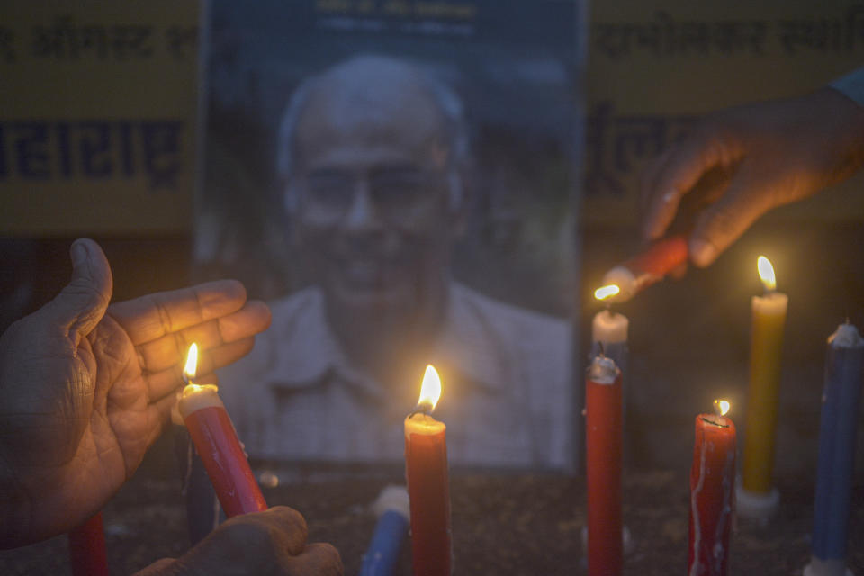 Members of the Maharashtra Andhashraddha Nirmulan Samiti, an anti-superstition group, light candles near a photograph of its founder and renowned rationalist, Narendra Dabholkar, who was gunned down during a morning walk 10 years ago, at his anniversary vigil in Pune, India, Saturday, Aug 19, 2023. The nones in India come from an array of belief backgrounds, including Hindu, Muslim and Sikh. The surge of Hindu nationalism has shrunk the space for the nones over the last decade, activists say. (AP Photo/ Shankar Narayan)