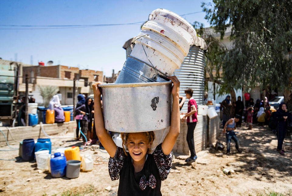 Image: Syrian child carries containers to collect water provided by the UNICEF in Syria's northeastern city of Hasakeh, (Delil Souleiman / AFP - Getty Images)