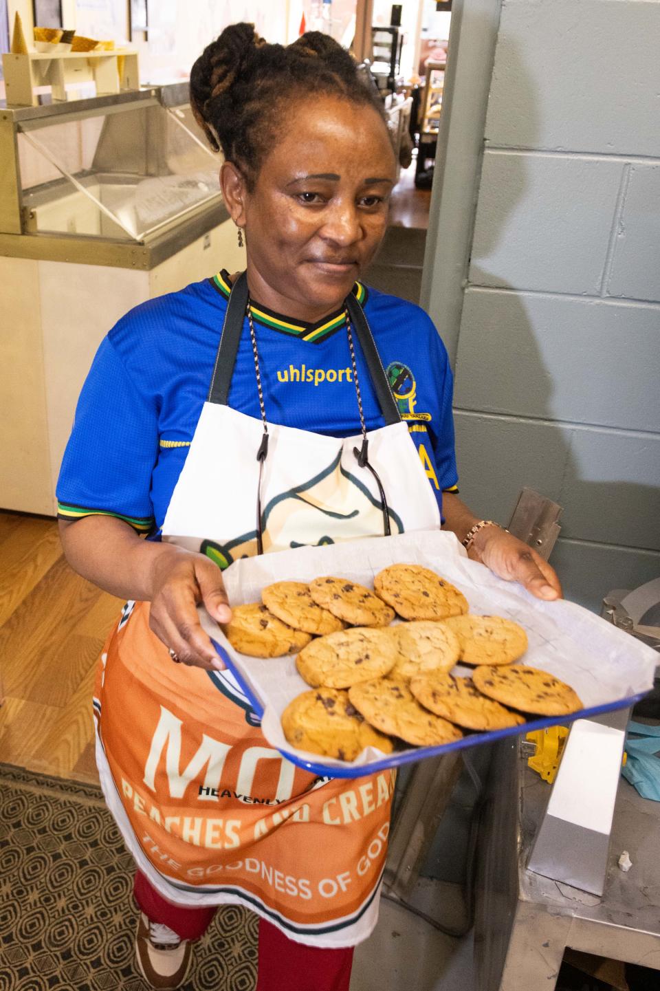 Joan Robin carries a tray of freshly baked cookies on Nov. 15 at the newly opened Peaches & Cream.
