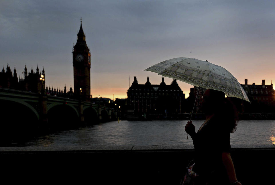 Jul 27, 2012; London, United Kingdom; A pedestrian walks down the road with Big Ben in the background carrying an umbrella as rain falls during the Opening Ceremonies to start the 2012 Olympic Games. Mandatory Credit: Andrew Weber-USA TODAY Sports