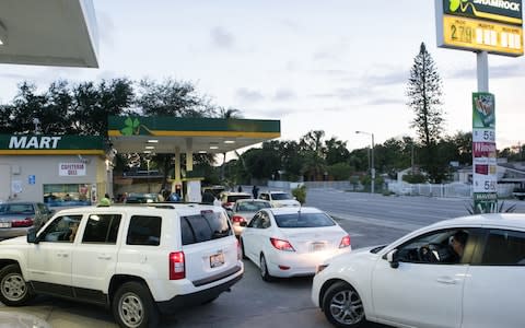 Vehicles sit lined up waiting to get fuel from a gas station ahead of Hurricane Irma in Miami - Credit: Bloomberg