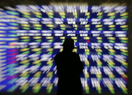 A man looks at at an electronic stock quotation board outside a brokerage in Tokyo January 14, 2014. REUTERS/Issei Kato