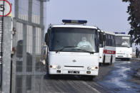 Busses with passengers from the Ukrainian aircraft chartered by the Ukrainian government for evacuation from the Chinese city of Wuhan, leave the the gate upon their landing at airport outside Kharkiv, Ukraine, Thursday, Feb. 20, 2020. Ukraine's effort to evacuate more than 70 people from China due to the outbreak of the new COVID-19 virus was delayed because of bad weather as evacuees travel to a hospital where they are expected to be quarantined. (AP Photo/Igor Chekachkov)