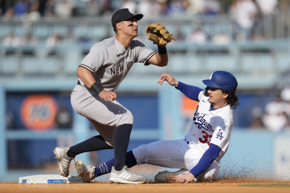 Los Angeles Dodgers' James Outman (33) steals second base ahead of a throw to New York Yankees shortstop Anthony Volpe (11) during the sixth inning of a baseball game in Los Angeles, Sunday, June 4, 2023. (AP Photo/Ashley Landis)