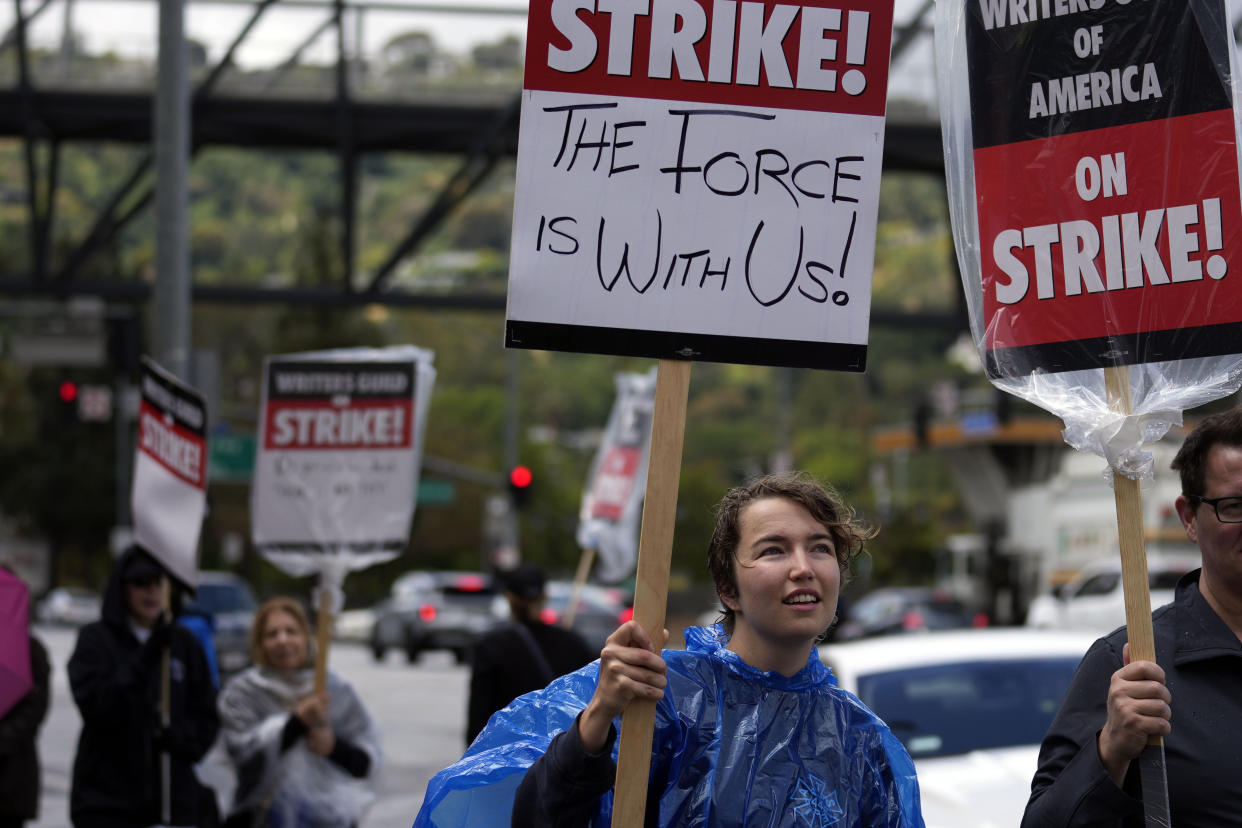 Writer Olivia Dom pickets with fellow members of The Writers Guild of America outside of Universal Studios Thursday, May 4, 2023, in Universal City, Calif. The first Hollywood strike in 15 years commenced Tuesday as the 11,500 members of the Writers Guild of America stopped working when their contract expired. (AP Photo/Marcio Jose Sanchez)