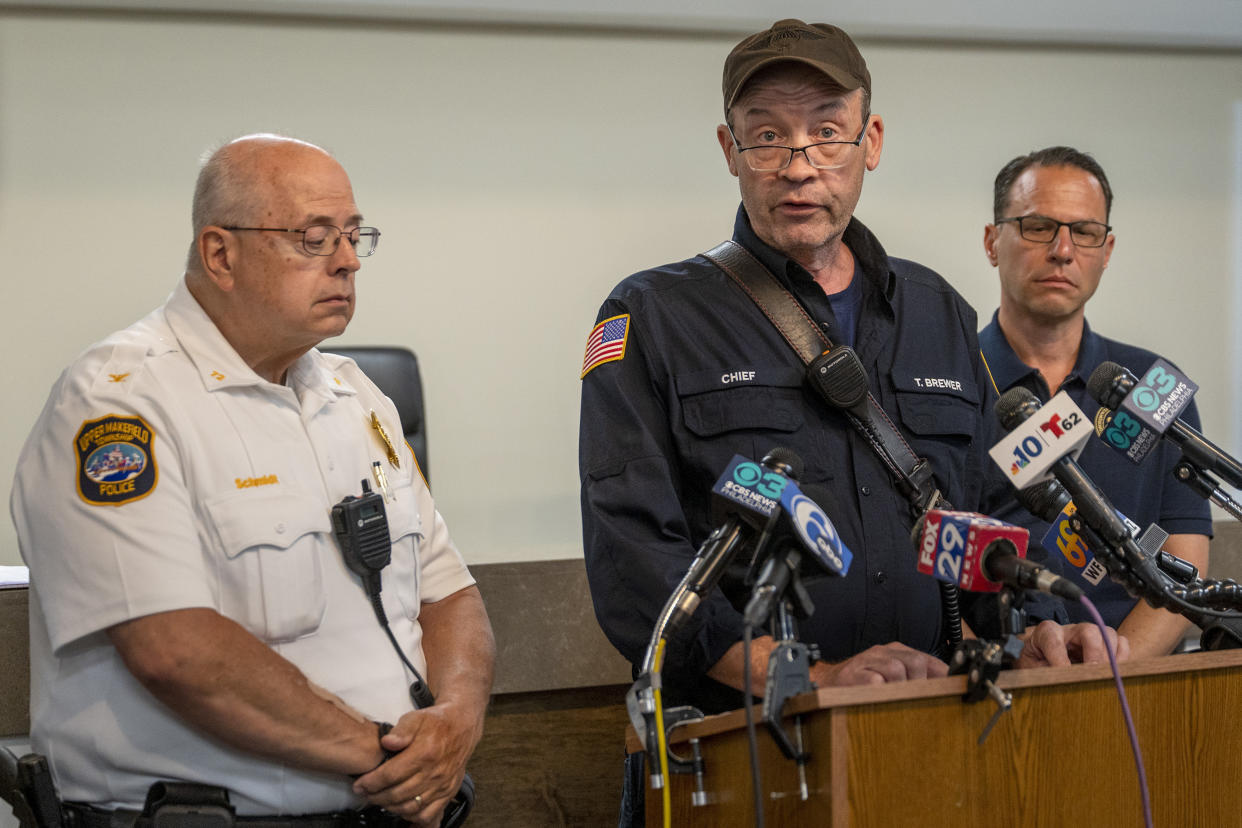 Gov. Josh Shapiro, right, looks on as Upper Makefield Fire Chief Tim Brewer speaks during a news media update at the Upper Makefield police headquarters in Makefield, Pa., Sunday, July 16, 2023, following fatal flash flooding on Saturday. Upper Makefield Chief of Police Mark Schmidt is at left. (Tom Gralish/The Philadelphia Inquirer via AP)