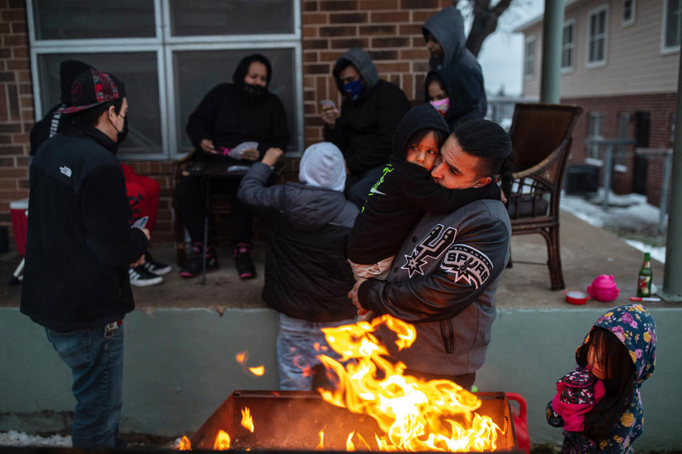 Image: Eric Traugott warms up his young son, Eric Traugott Jr., beside a fire, made from a discarded wooden armoire outside of their apartment in Austin, Texas, that remains without power on Feb. 17, 2021. (Tamir Kalifa/The New York Times) (Tamir Kalifa / The New York Times via Redux)