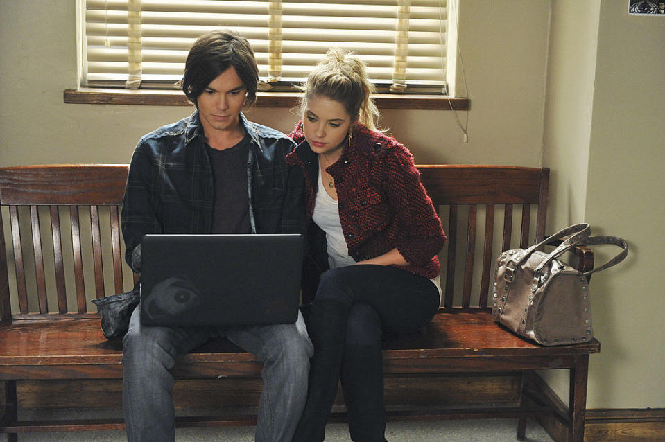 Caleb and Hanna sitting on a bench and looking at a laptop